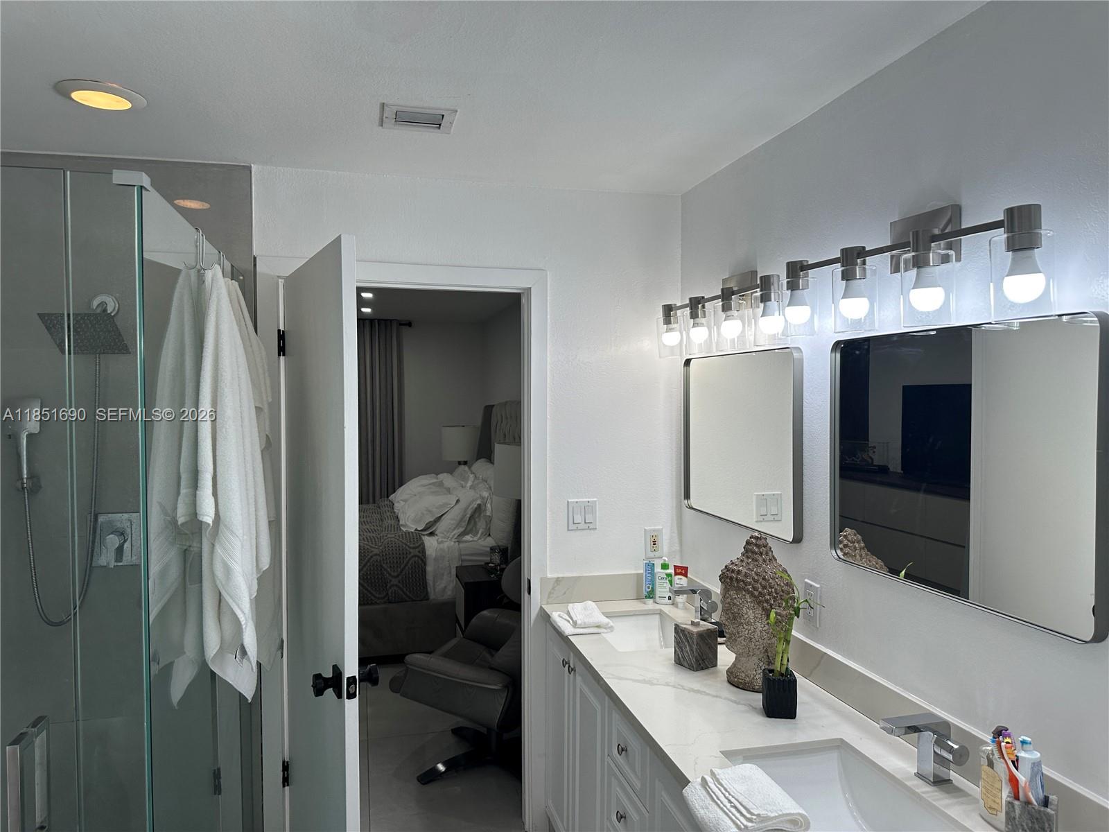 11 Northeast 151st Street Miami, FL 33162 - Photo 35 of 95 a en suite bathroom with a double vanity sink mirror and shower