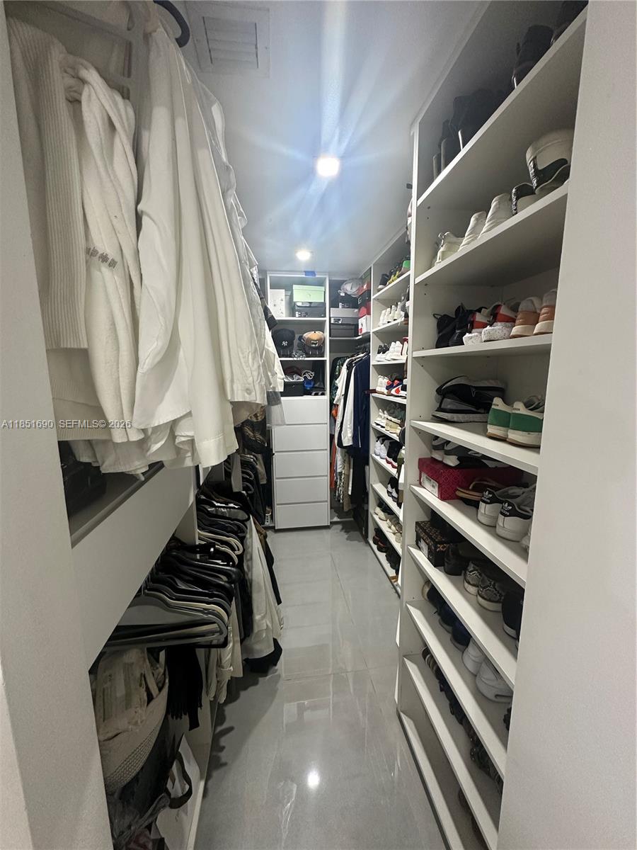 11 Northeast 151st Street Miami, FL 33162 - Photo 38 of 95 a view of walk in closet with clothes and shoes