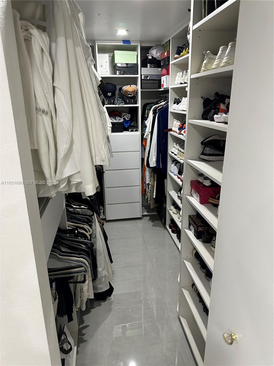 11 Northeast 151st Street Miami, FL 33162 - Photo 39 of 95 a view of walk in closet with clothes and shoes
