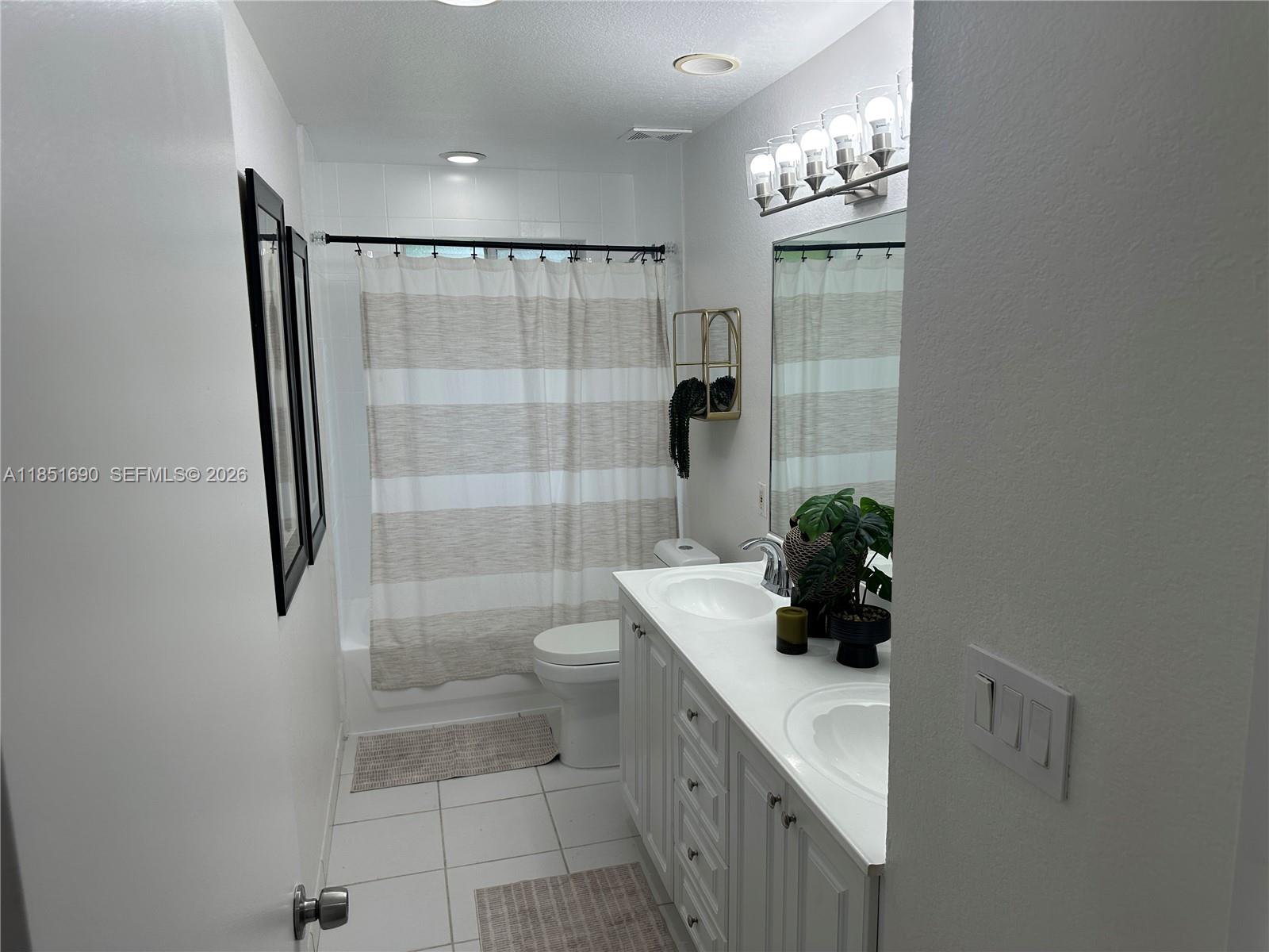 11 Northeast 151st Street Miami, FL 33162 - Photo 52 of 95 a bathroom with a toilet a sink and shower
