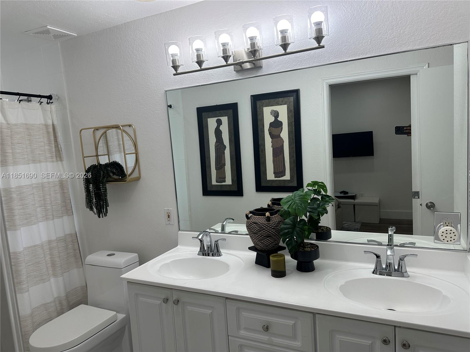 11 Northeast 151st Street Miami, FL 33162 - Photo 53 of 95 a bathroom with a toilet sink and mirror