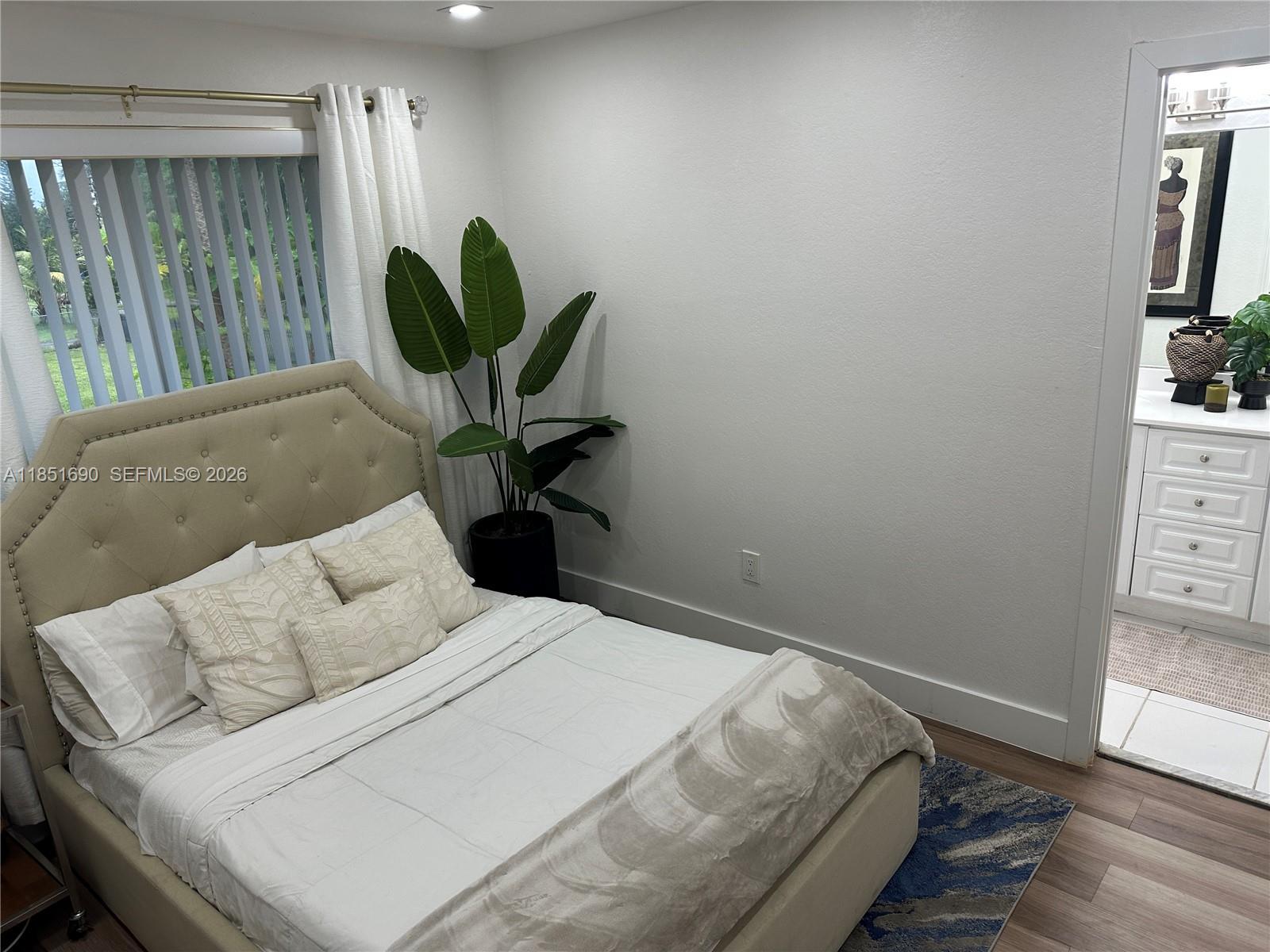 11 Northeast 151st Street Miami, FL 33162 - Photo 60 of 95 a bedroom with a bed and wooden floor
