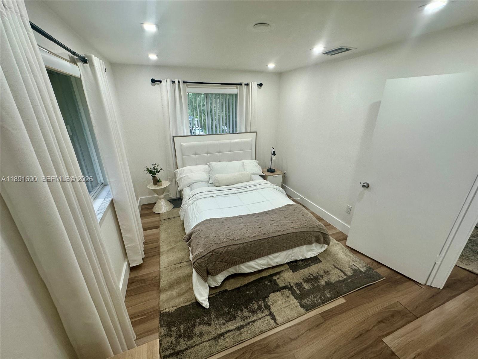 11 Northeast 151st Street Miami, FL 33162 - Photo 69 of 95 a bedroom with a bed and a mirror