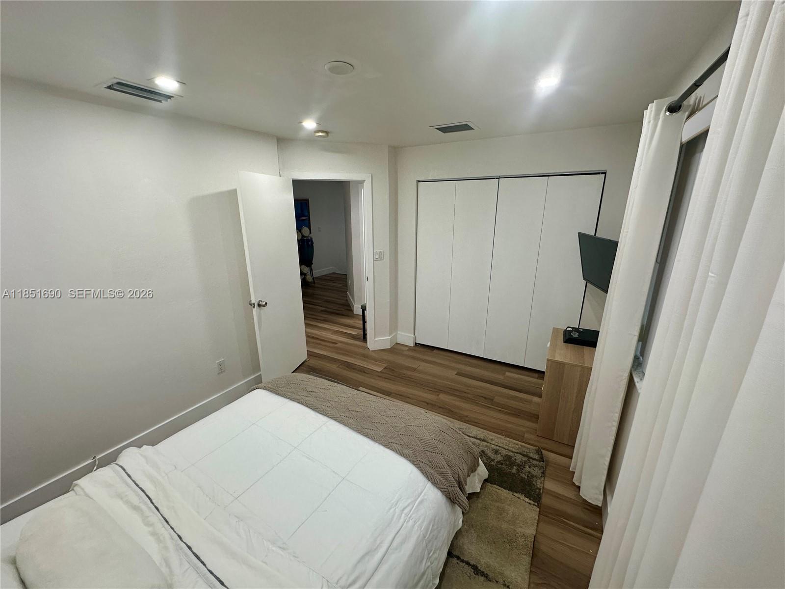 11 Northeast 151st Street Miami, FL 33162 - Photo 70 of 95 a bedroom with a bed and a mirror
