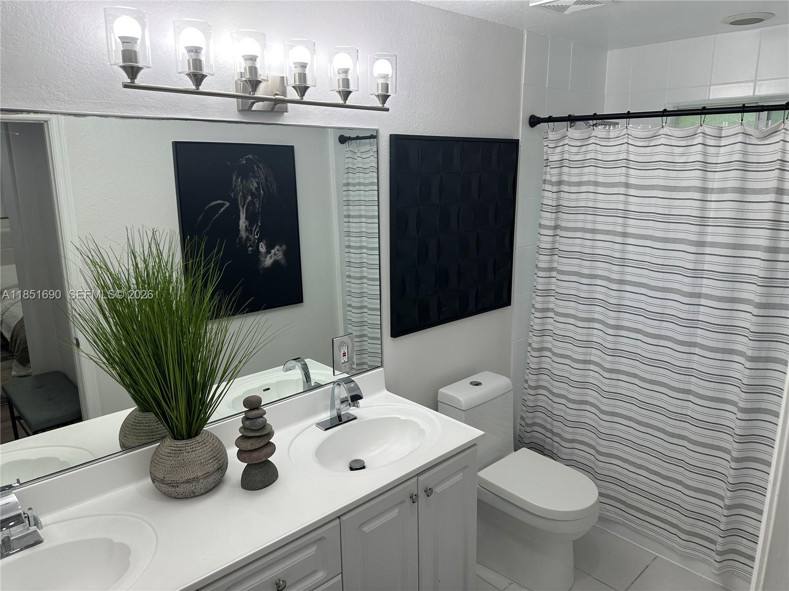 11 Northeast 151st Street Miami, FL 33162 - Photo 79 of 95 a bathroom with a sink a toilet and mirror