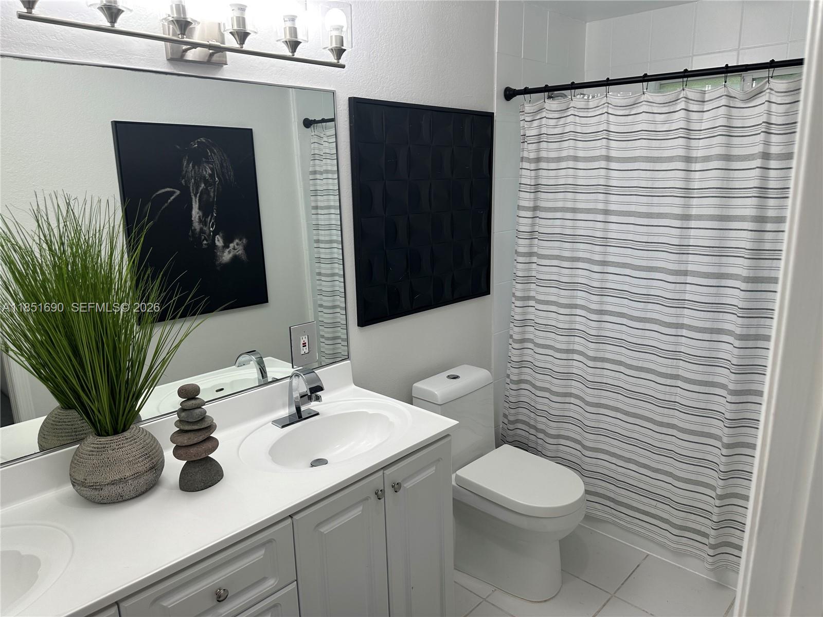 11 Northeast 151st Street Miami, FL 33162 - Photo 82 of 95 a bathroom with a toilet a sink and mirror