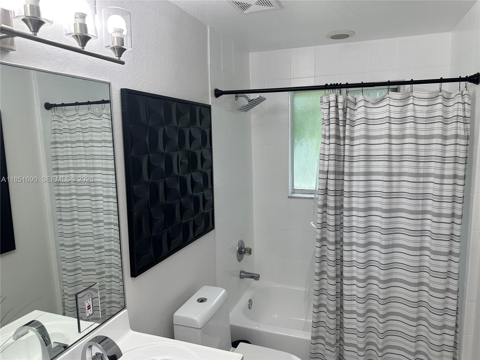 11 Northeast 151st Street Miami, FL 33162 - Photo 83 of 95 a bathroom with a shower curtain and a sink