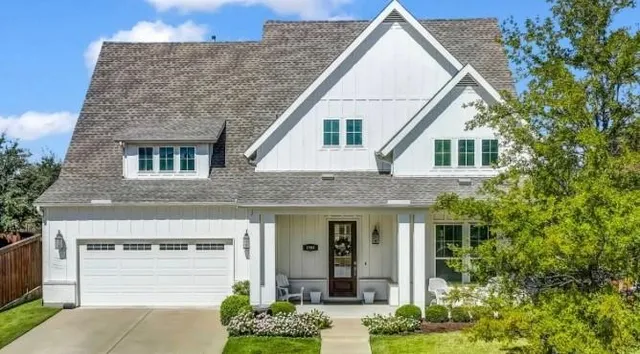 a view of a white house next to a yard