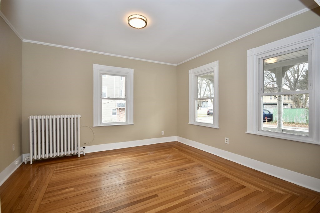 253 Adams Street Fairhaven, MA 02719 - Photo 5 of 17 a view of an empty room with wooden floor and a window