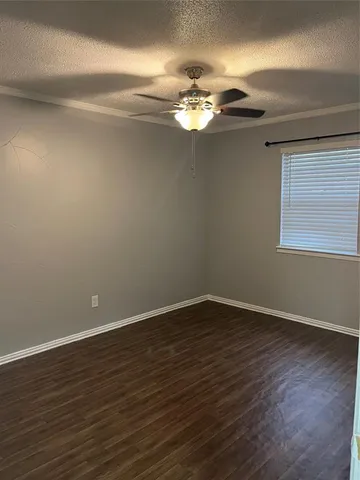 a view of an empty room with wooden floor and chandelier