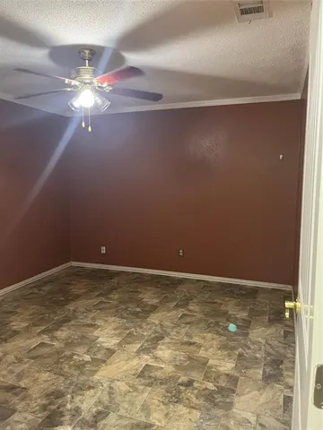 a view of an empty room with a chandelier fan