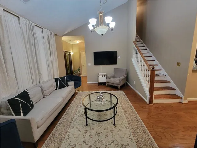 a living room with furniture a rug a lamp and a flat screen tv