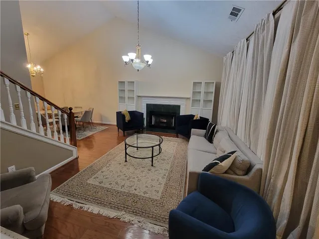 a living room with furniture a fireplace and a chandelier