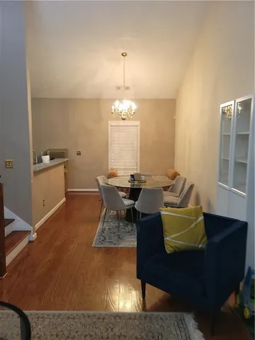 a living room with dining table chairs a dining table and a piano table