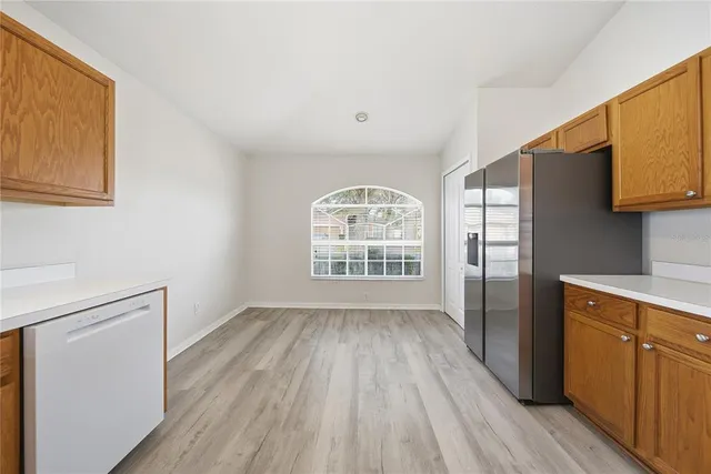 a view of kitchen with wooden floor electronic appliances and window
