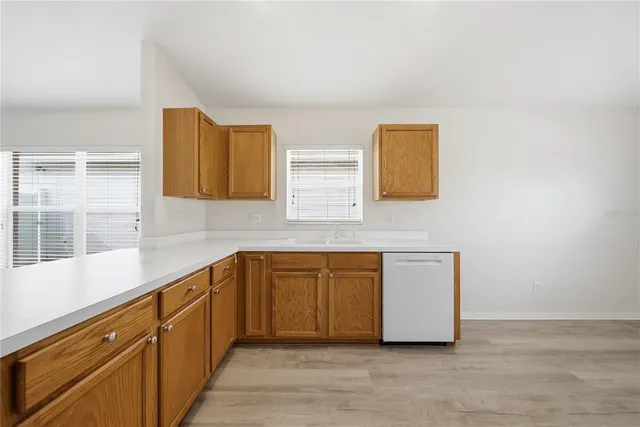 a view of a kitchen with wooden floor and a sink
