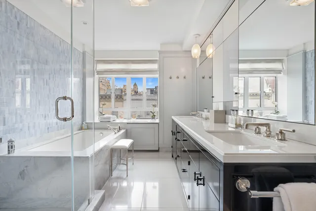 a bathroom with a double vanity sink a mirror and a bathtub