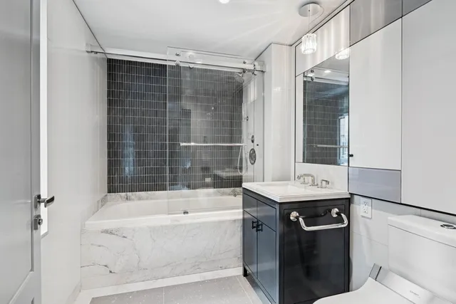 a bathroom with a granite countertop sink a bathtub and shower