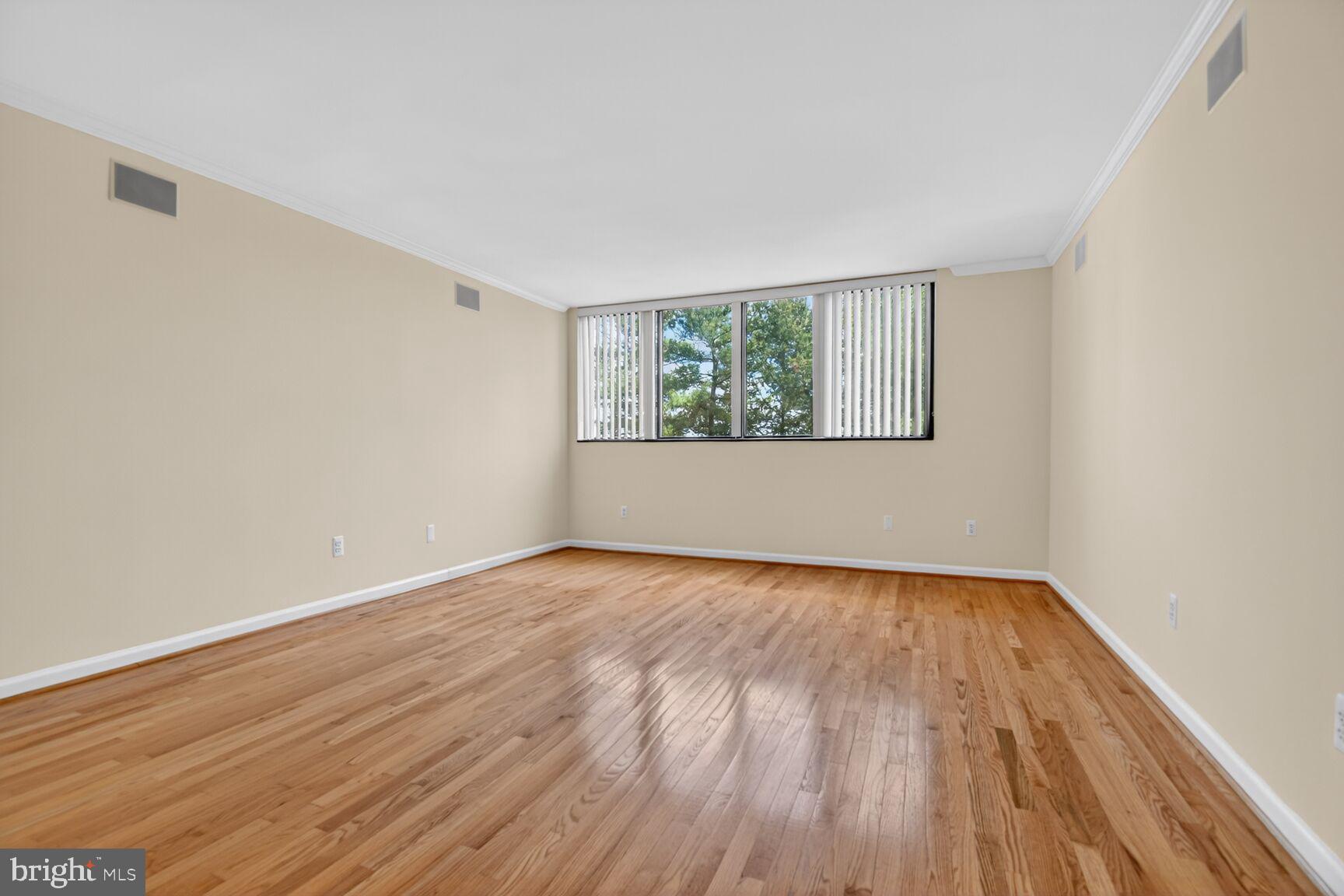 1101 South Arlington Ridge Road, Unit 504 Arlington, VA 22202 - Photo 16 of 37 an empty room with wooden floor and windows