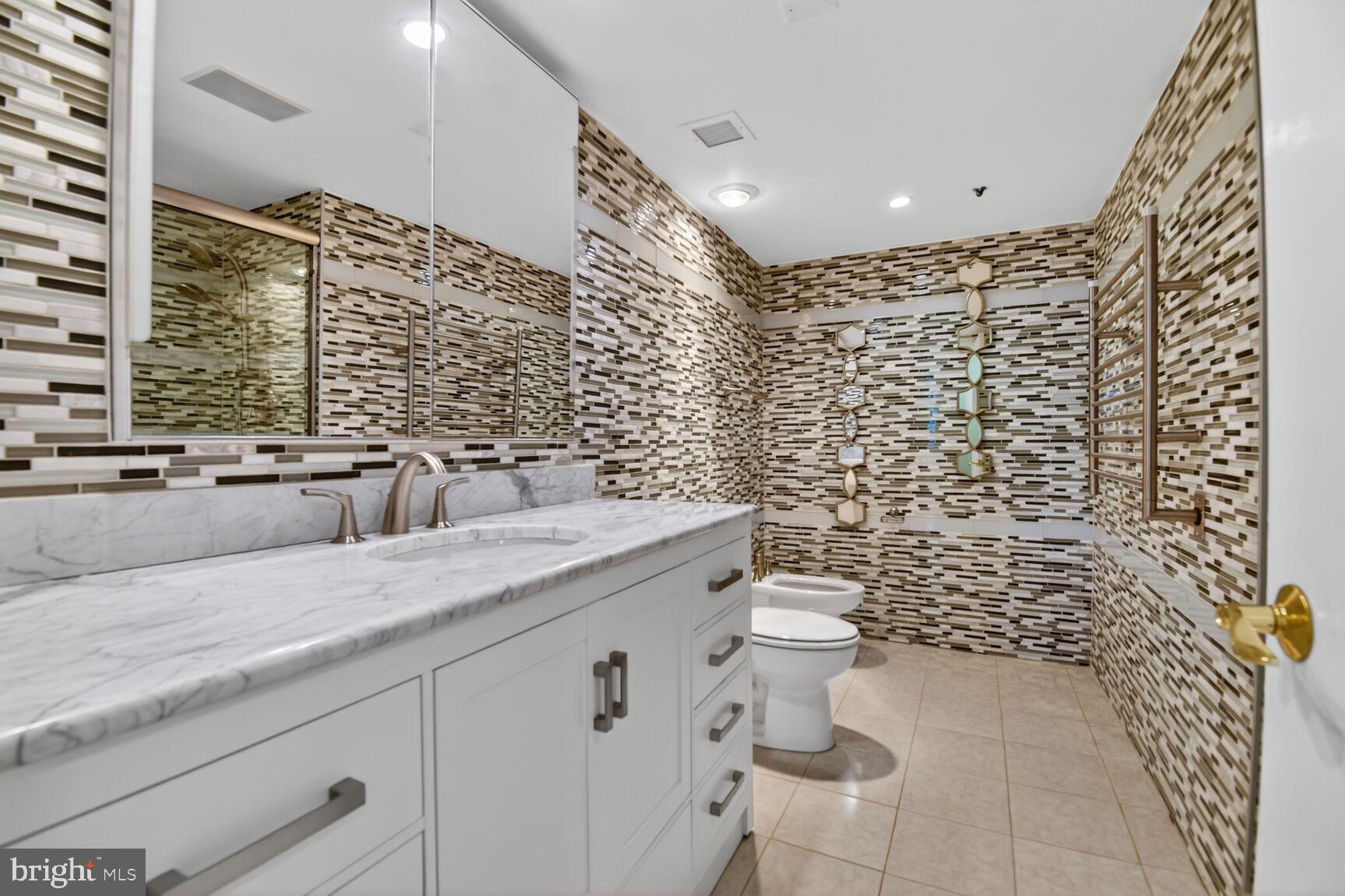 1101 South Arlington Ridge Road, Unit 504 Arlington, VA 22202 - Photo 19 of 37 a bathroom with a granite countertop toilet sink and mirror