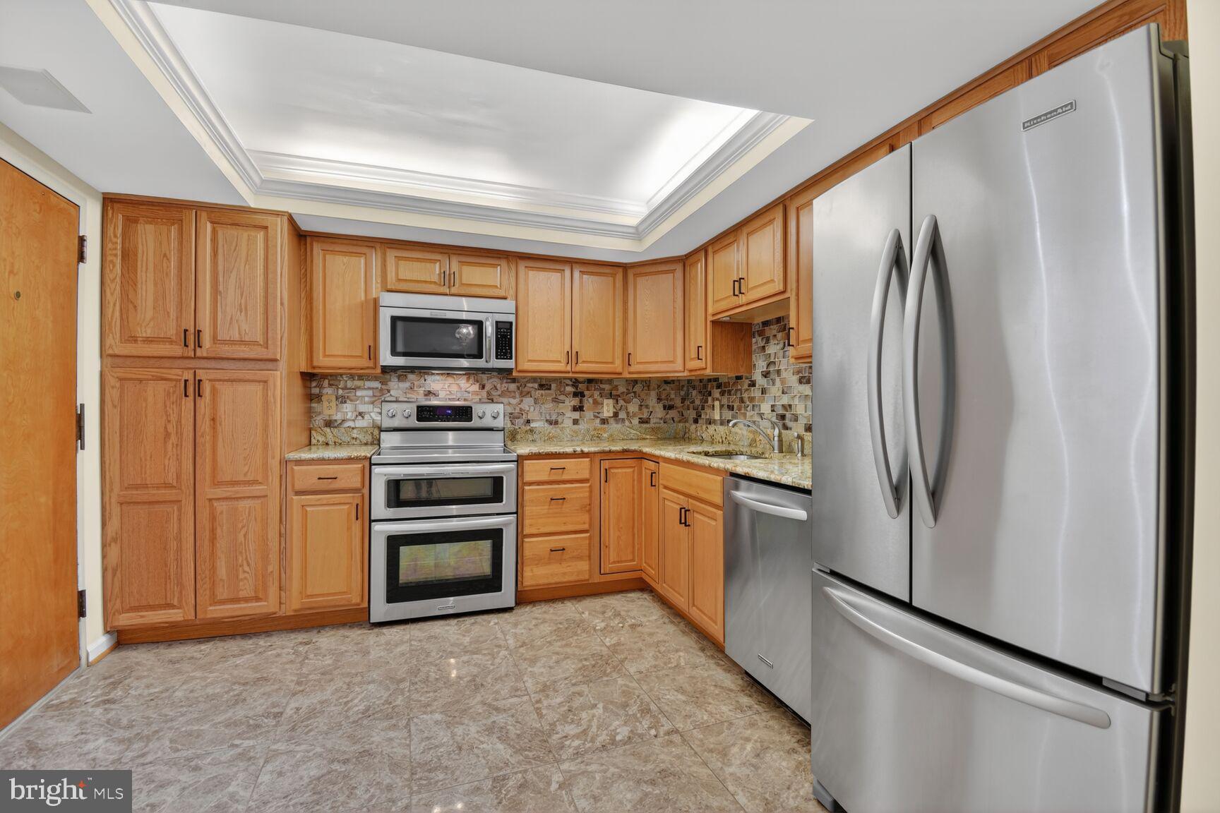 1101 South Arlington Ridge Road, Unit 504 Arlington, VA 22202 - Photo 6 of 37 a kitchen with granite countertop a refrigerator stove and microwave
