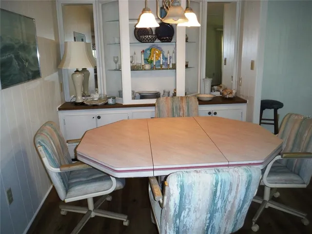 a room with table chairs and wooden floor