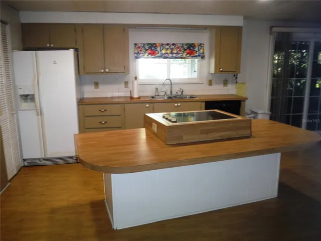 a kitchen with sink a refrigerator and window