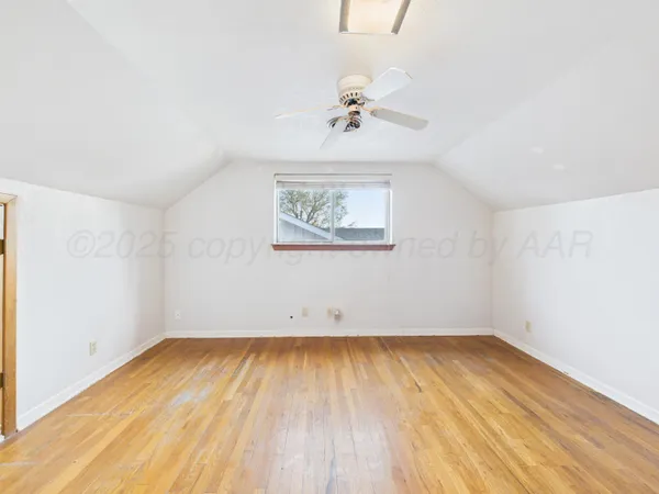 an empty room with a window and a ceiling fan