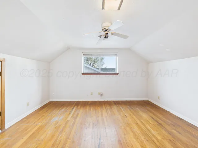 an empty room with a window and a ceiling fan