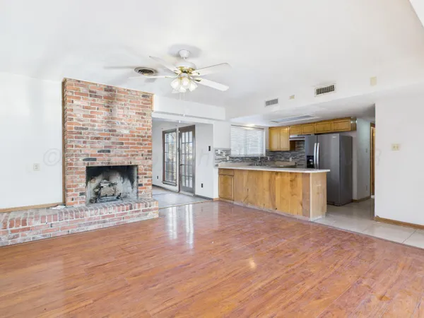 a view of empty room with wooden floor and fireplace