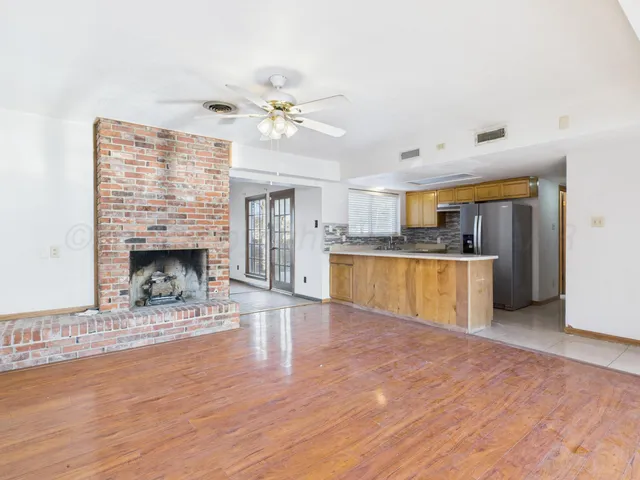 a view of empty room with wooden floor and fireplace
