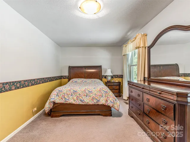 a bedroom with a bed and a flat tv screen on wall