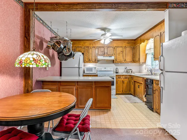 a kitchen with stainless steel appliances kitchen island granite countertop a sink a stove a dining table and chairs
