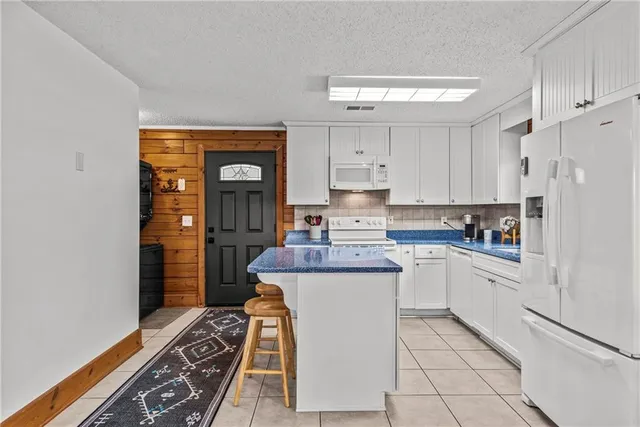 a kitchen with kitchen island a stove a sink and a refrigerator