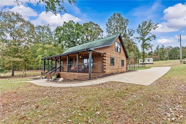 a view of a patio with a table chairs potted plants and a large tree