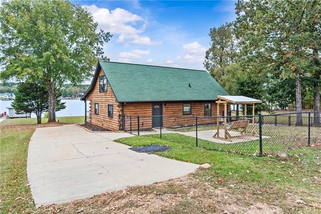 a front view of a house with a garden and tree