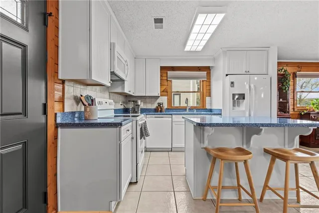 a kitchen with stainless steel appliances granite countertop a table chairs sink and cabinets