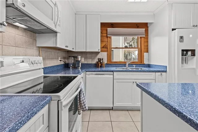 a kitchen with granite countertop a sink a stove and cabinets