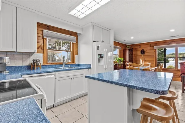 a kitchen with granite countertop a stove a sink and a refrigerator