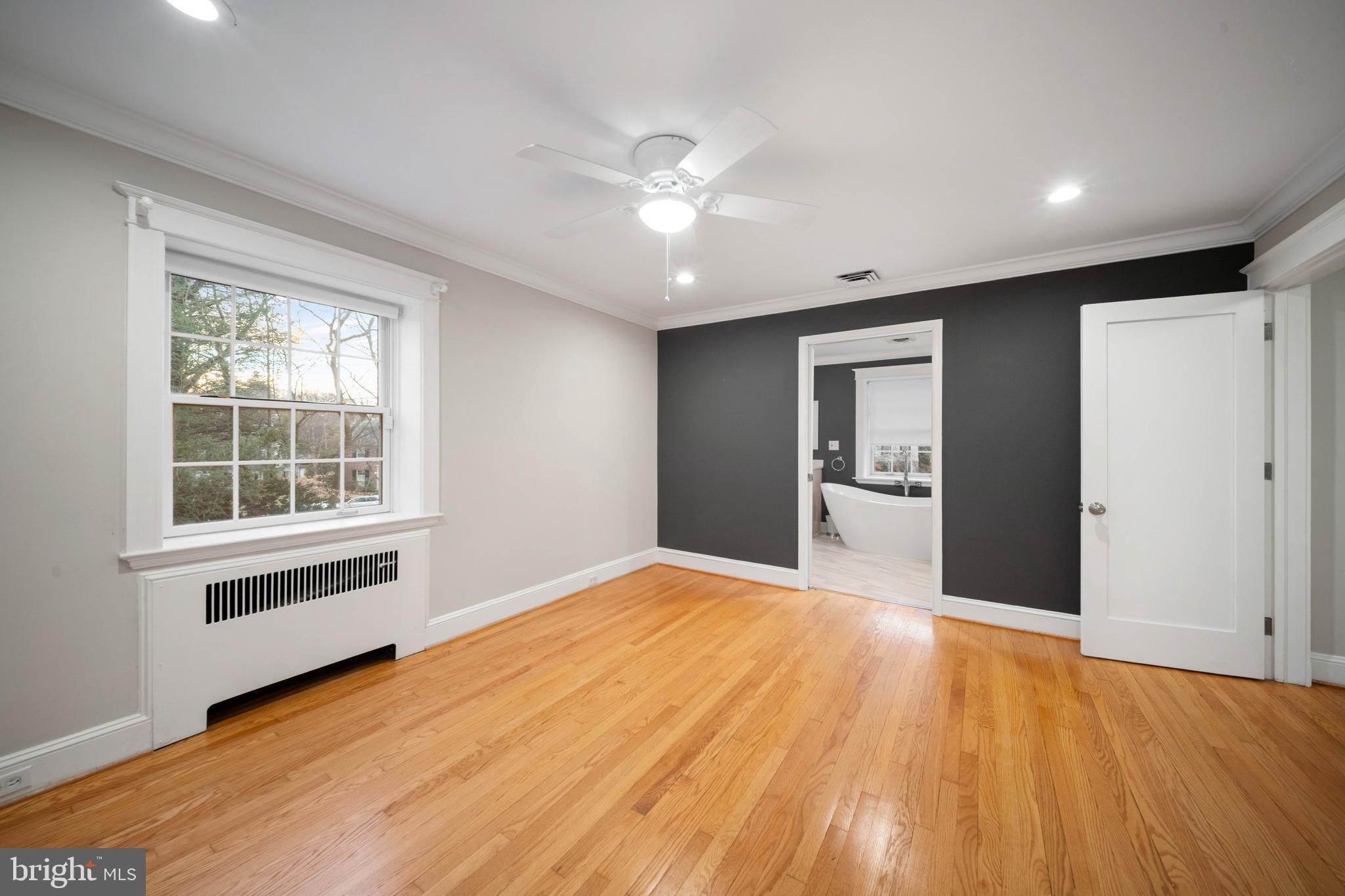 101 Thicket Road Baltimore, MD 21212 - Photo 22 of 30 a view of an empty room with window and wooden floor