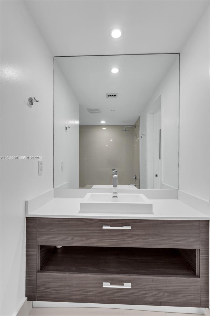 55 Southwest 9th Street, Unit 1109 Miami, FL 33130 - Photo 21 of 35 a bathroom with a sink a light fixture and a mirror
