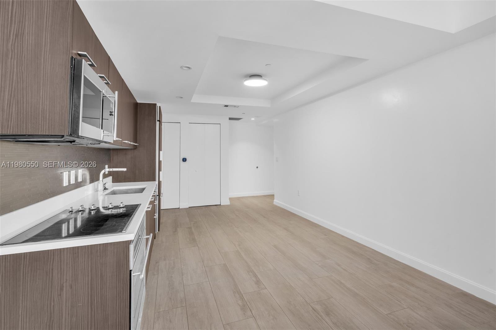 55 Southwest 9th Street, Unit 1109 Miami, FL 33130 - Photo 10 of 35 a kitchen with granite countertop a sink and a stove top oven