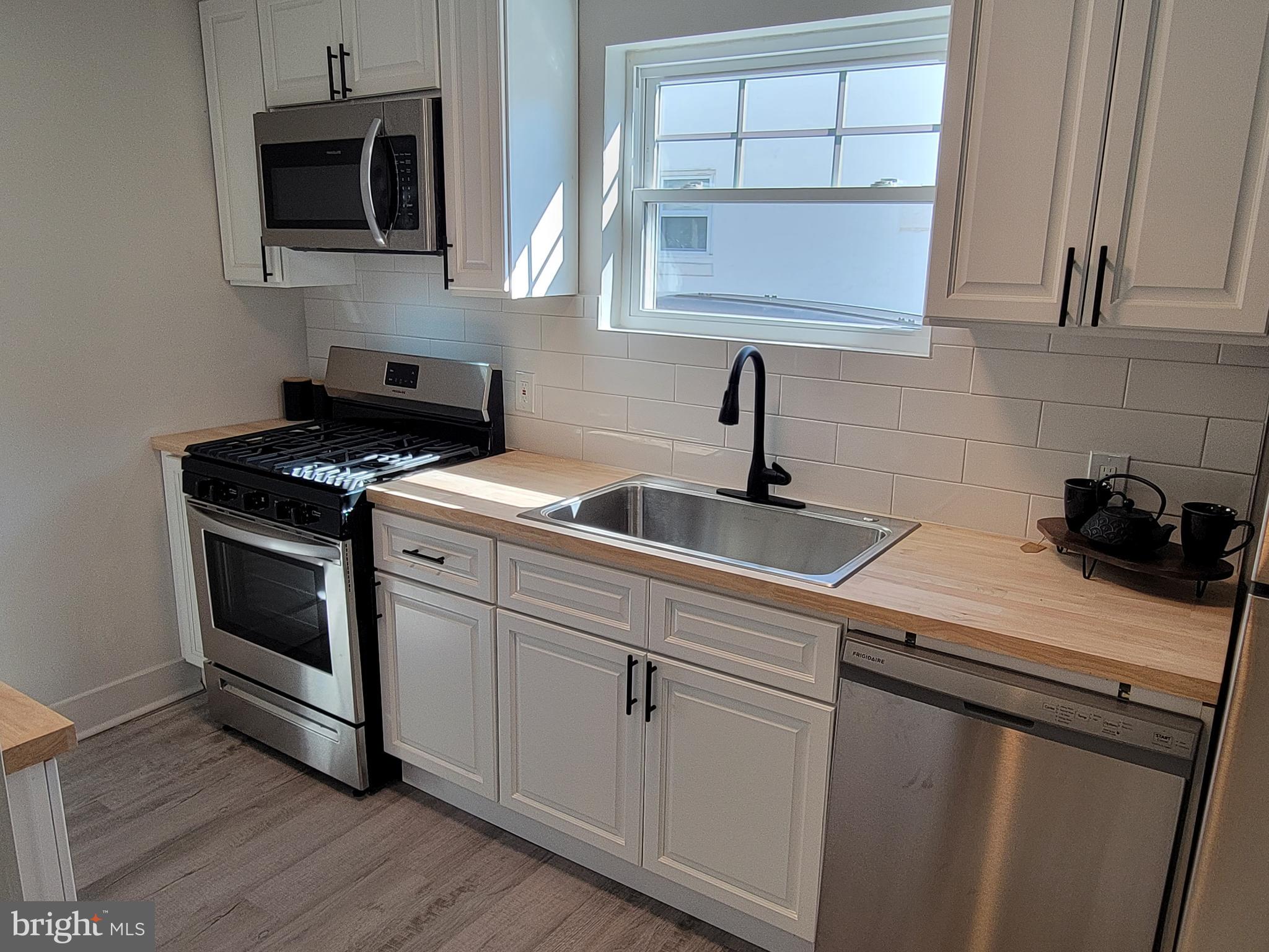 536 Crotzer Avenue Folcroft, PA 19032 - Photo 6 of 35 a kitchen with stainless steel appliances granite countertop a sink a stove a microwave and wooden cabinets