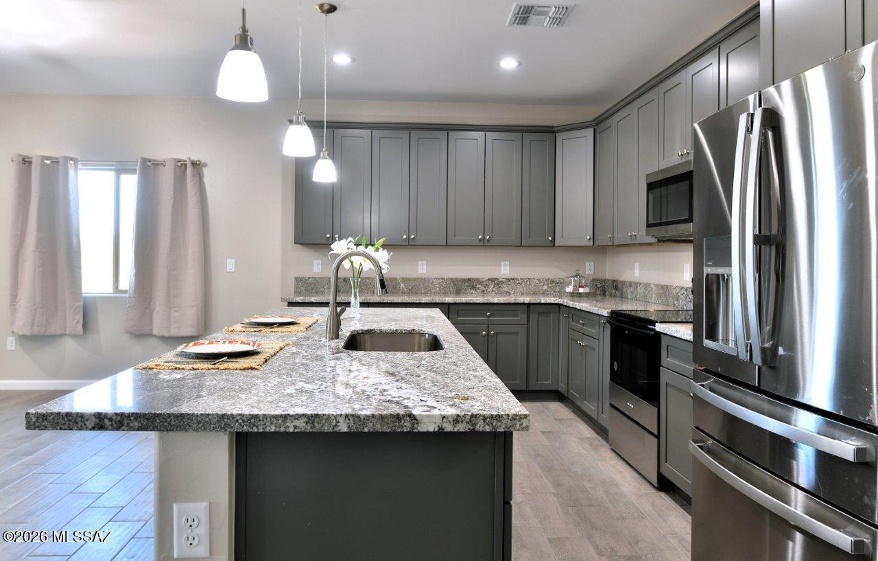 1091 North Vail View Road Vail, AZ 85641 - Photo 10 of 43 a kitchen with granite countertop a sink stainless steel appliances and cabinets