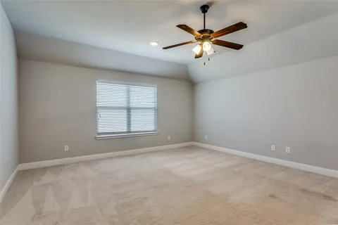 an empty room with ceiling fan and window
