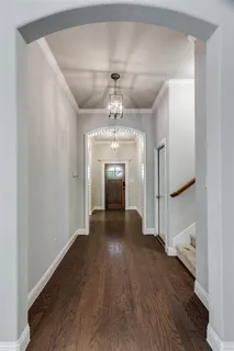 a view of a hallway with wooden floor and staircase