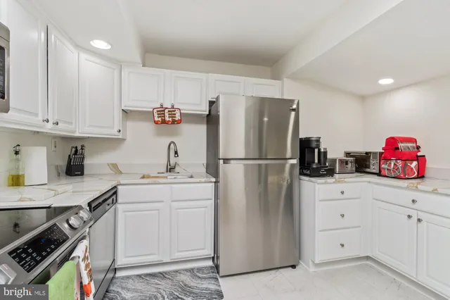 a kitchen with stainless steel appliances a refrigerator sink and cabinets