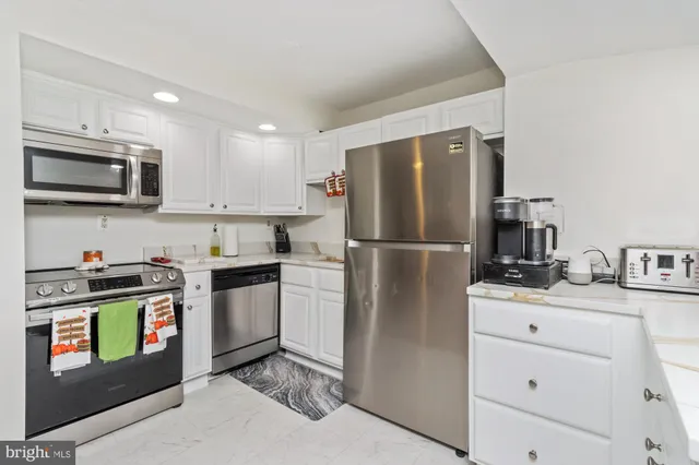 a kitchen with stainless steel appliances granite countertop a refrigerator stove a sink and a microwave