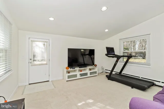 a living room with furniture gym equipment and a window