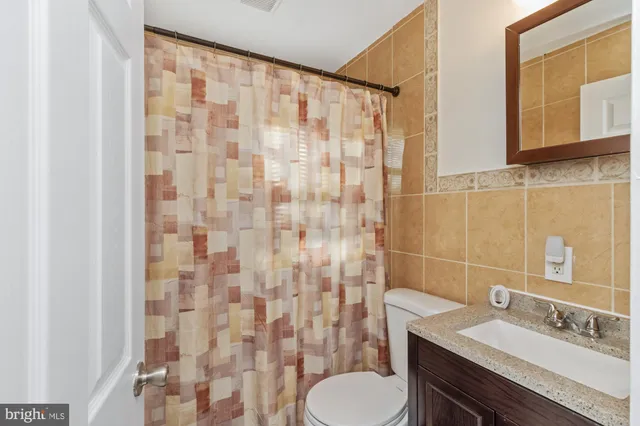 a bathroom with a granite countertop toilet a sink and a shower